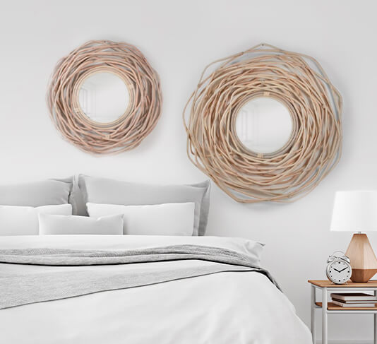 a light bedroom with large and medium round polished rattan mirrors